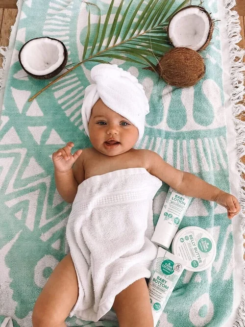 Baby on towel with Think Coconut Baby Range